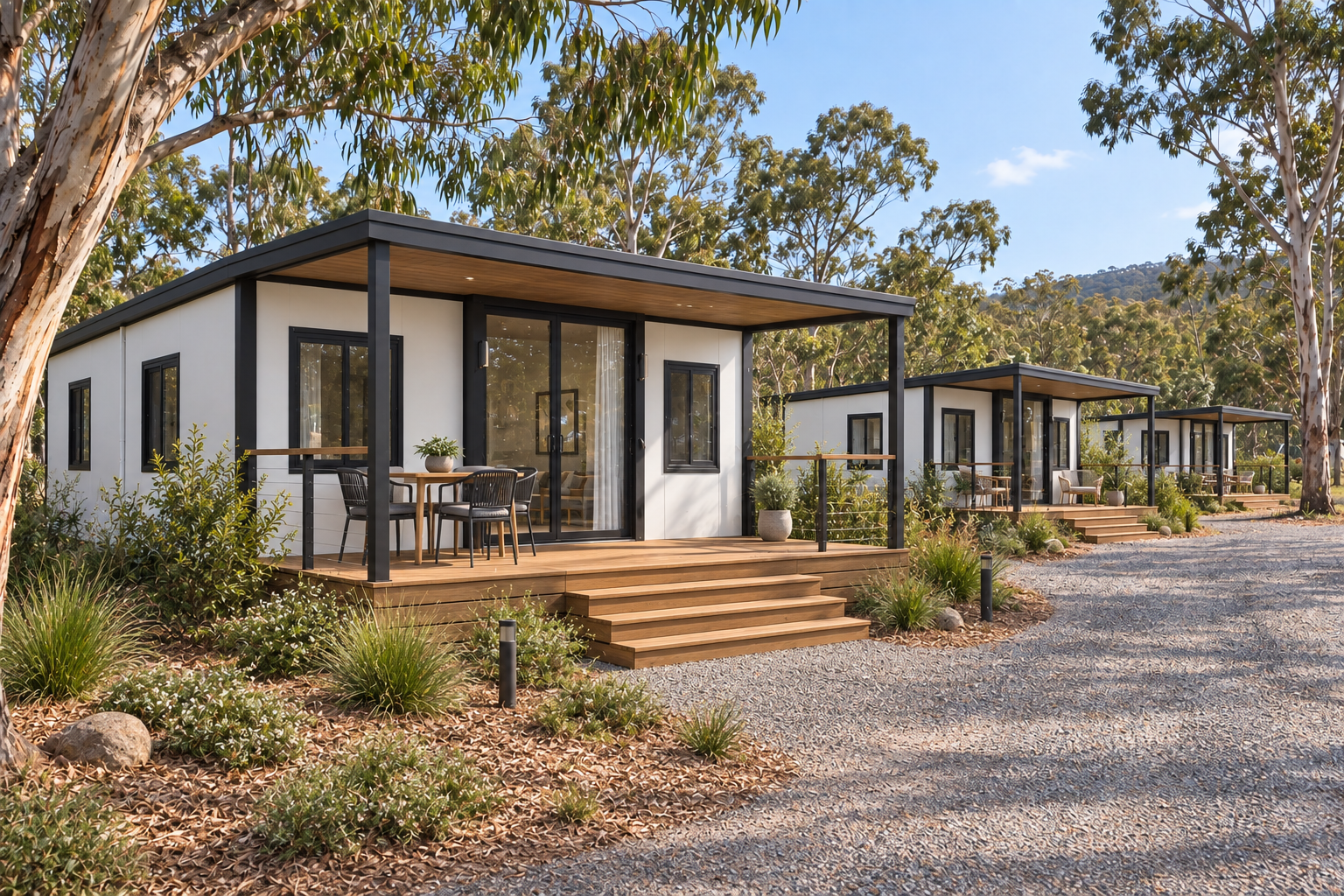 Expandable cabins with covered decks among gum trees in a tourist park